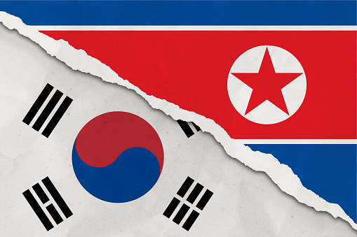 Corea del Sur y la bandera de Corea del Norte rasgaron el fondo grunge de papel photo