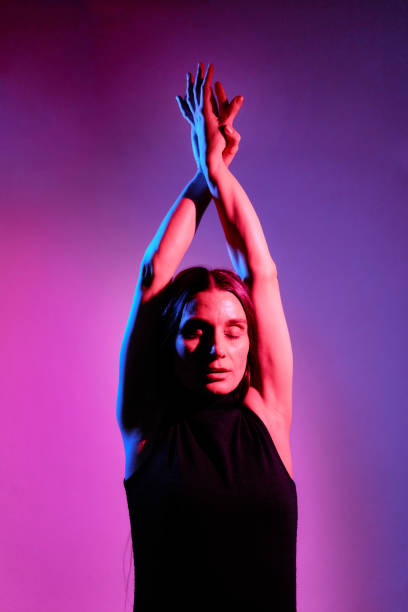 istock Beautiful woman studio portrait with red and blue flash lights. 1387797031
