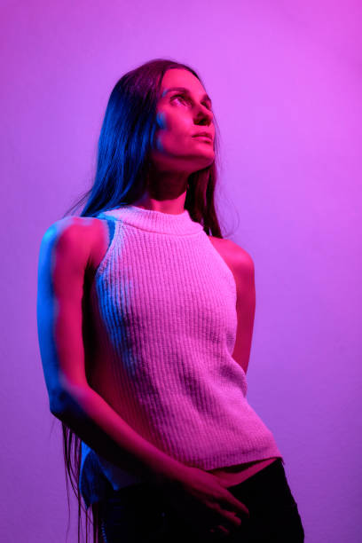 istock Beautiful woman studio portrait with red and blue flash lights. 1387797033