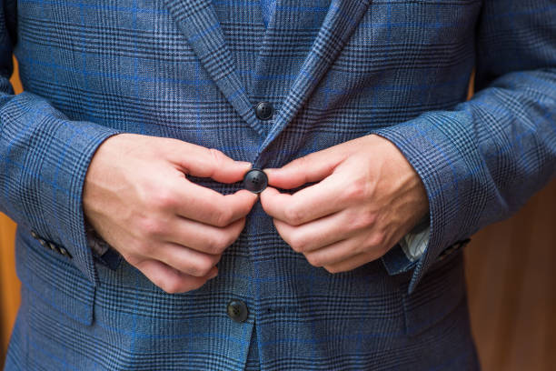 un hombre sujeta un botón en un traje elegante - garment mannequin men store fotografías e imágenes de stock