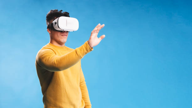Man using VR headset while experiencing the virtual reality over an isolated background. stock photo