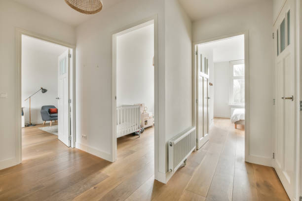The interior of a spacious corridor in the apartment, in white with parquet floor