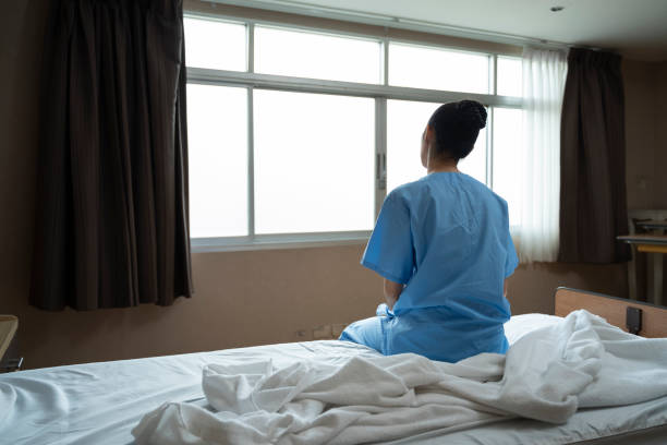 Long term patient with special treatment care plan is lonely sitting with depression while looking out the window for hopeful recovery progress and ptsd concept