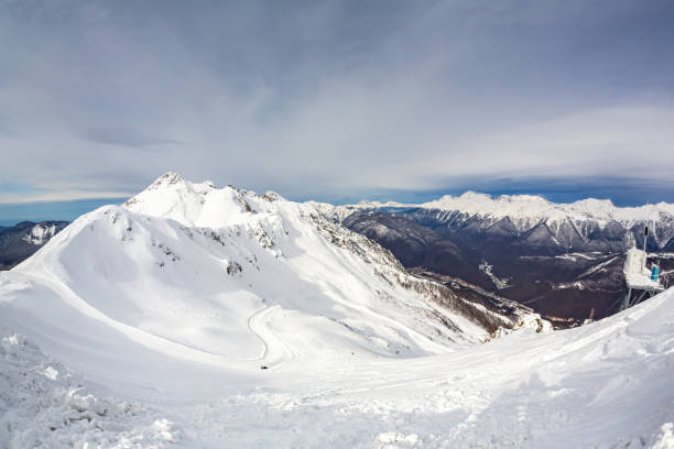 istock Snow-covered mountain ranges covered with coniferous forests in the clouds 1387802448