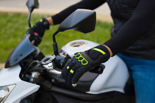 une main gauche recouverte de gants d’un homme posé sur le volant d’une motocyclette - motorcycle mirror biker glove photos et images de collection