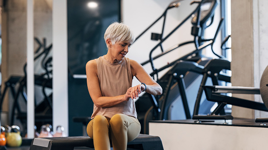 A Determined Woman Checking Her Pulse Using Her Smartwatch App While Taking A Break From Her Workout