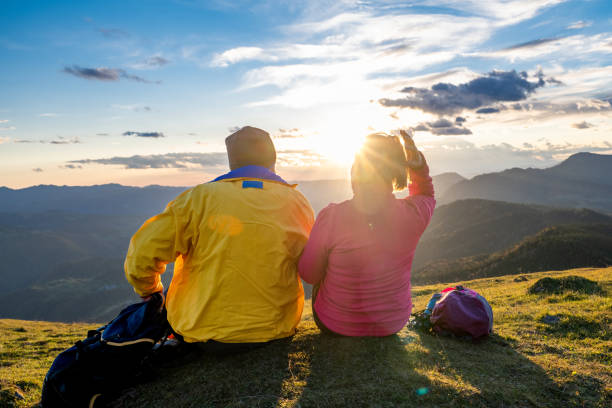 istock Pair relaxing in nature, panoramic view of mountain ridge 1387813951