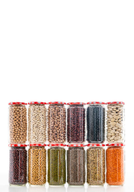 istock Assorted legumes in glass jar in a row on white background 1387814721