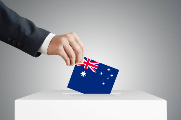 istock Man putting a ballot into a voting box. 1387814880