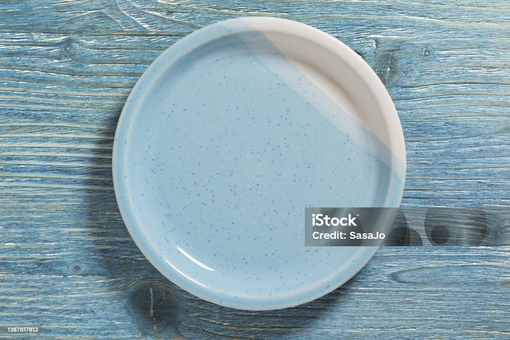 Empty blue plate Empty blue plate on old wooden table, top view Blue Stock Photo