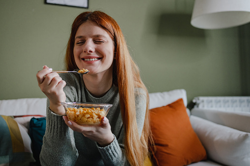 Close up of a woman eating cereals at home