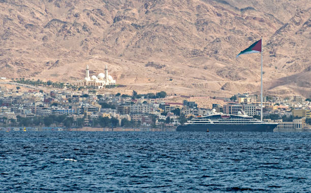 aqaba city, marine port with cruise ship, above is the flag of arab revolt - gulf of aqaba imagens e fotografias de stock