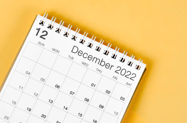 istock December 2022 desk calendar on light yellow background. 1387820426