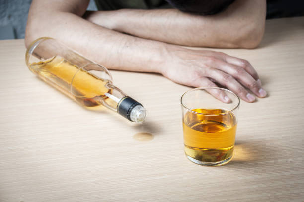 betrunkener mann sitzt an der bar - alcoholism narcotic excess alcohol stock-fotos und bilder