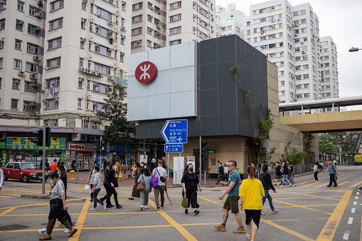 Hong Kong - March 26, 2022 : People walk past the MTR Whampoa station in Hung Hom, Kowloon, Hong Kong.
