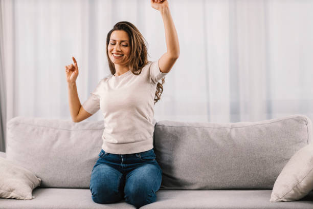 istock A woman dances on the sofa at home. 1387824397
