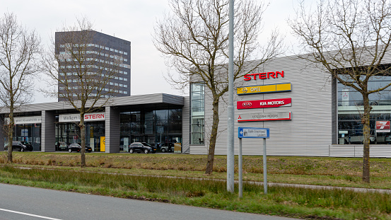 Assen, Drenthe, Netherlands, march 20th 2022, exterior of car dealership Stern at the Balkenweg street in Assen as seen while driving by, in the backgound on the left is the highrise building of police station \