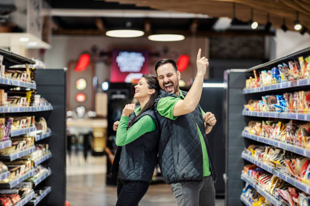 Playful employees dancing in supermarket. stock photo