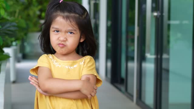Portrait of funny Asian angry and sad little girl, The emotion of a child when tantrum and mad, expression grumpy emotion. Kid emotional control concept