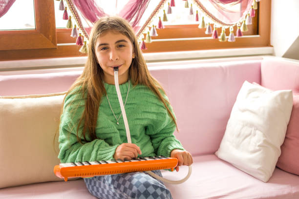 Child girl with musical instrument sitting on sofa