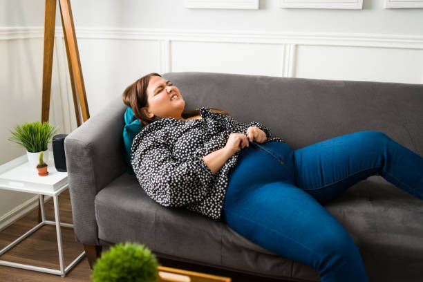 istock Sad fat woman struggling with her jeans 1387840038
