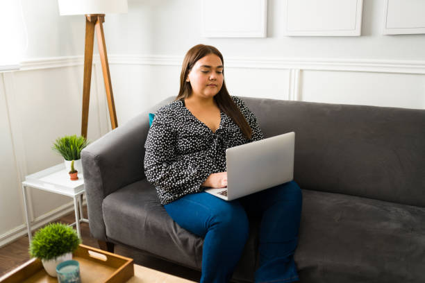 istock Attractive fat woman using a laptop 1387840169