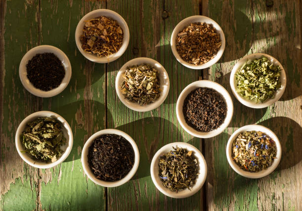 istock Different kinds of tea or herbs in bowls on an old table in the sunset 1387840971