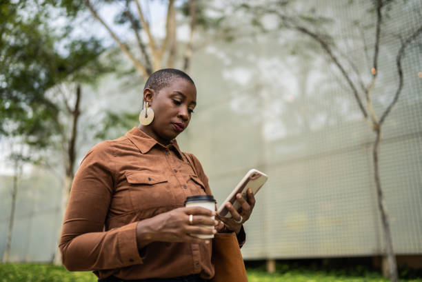istock Business woman using smartphone outdoors 1387842553