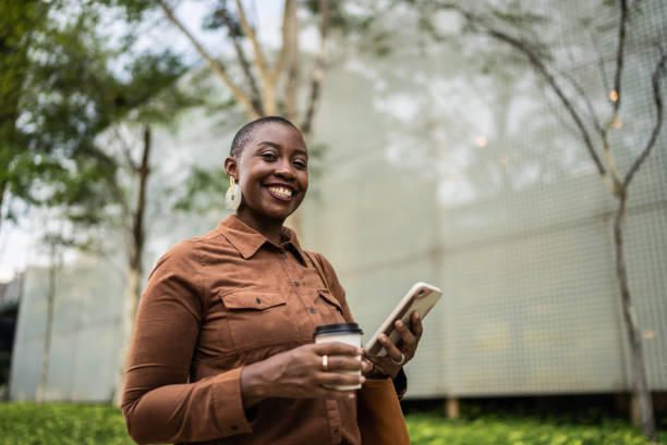 Portrait of a business woman using smartphone outdoors Portrait of a business woman using smartphone outdoors one mid adult woman only stock pictures, royalty-free photos & images