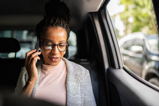 車の中で携帯電話で話す成熟した女性 - car smart phone business businesswoman ストックフォトと画像