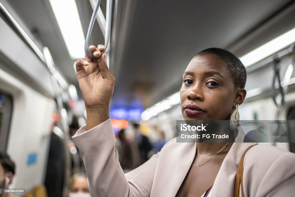 Portrait of an adult woman holding the handgrip on the subway train One Woman Only Stock Photo