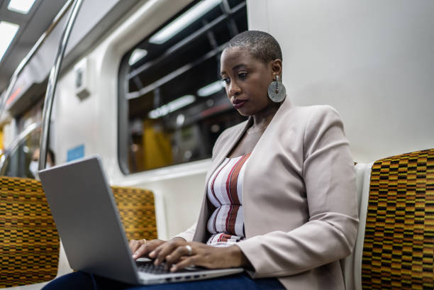 istock Businesswoman using the laptop in the subway train 1387843321
