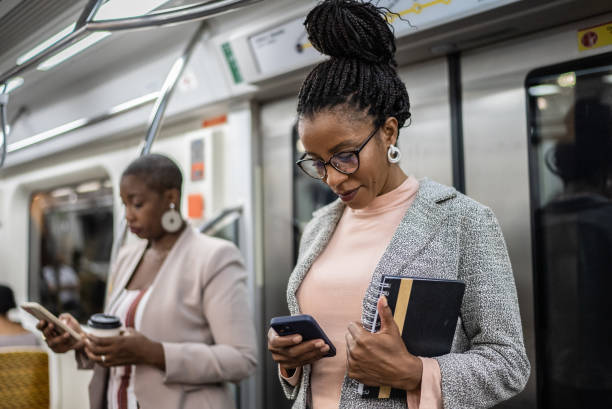 istock Mature woman using the mobile phone in the subway train 1387843342