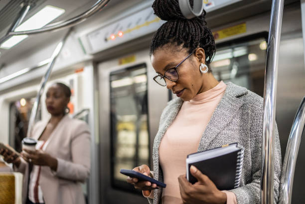 istock Mature woman using the mobile phone in the subway train 1387843347