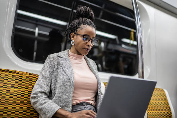 istock Mature woman using the laptop in the subway train 1387843349