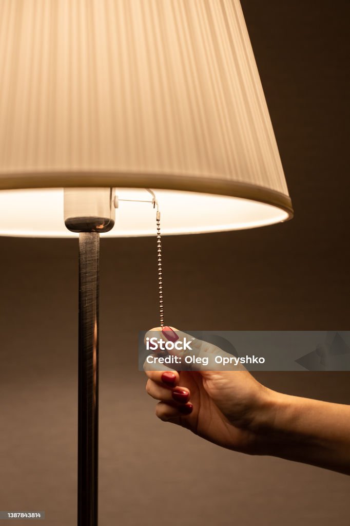 lamp night light by the rope which the hand pulls Turning On Or Off Stock Photo