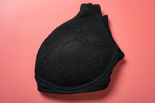 folded black bra for women close up on pink background stock photo