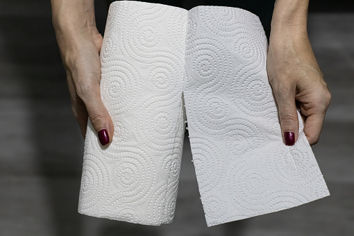 woman hand tears off white paper towel