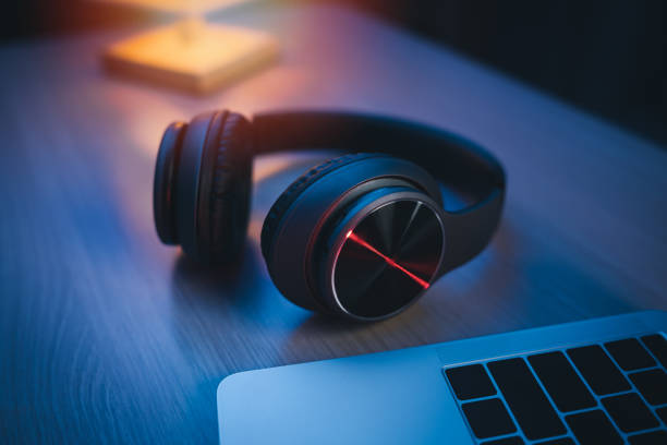istock Headphone on the table at home studio for recording and laptop using recording software to make music night light. Music production concept. 1387845808