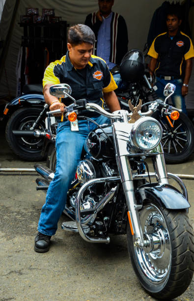 Man sitting on the Harley Davidson fat boy sporty bike for a ride. Shillong, India - October 05, 2012: Man sitting on the Harley Davidson fat boy sporty bike for a ride. harley davidson fat boy stock pictures, royalty-free photos & images