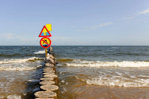 No jumping and large depth warning sign, placed on the breakwater on the beach in Kolobrzeg in Poland