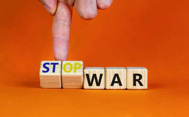 istock Stop war symbol. Businessman turns cubes and changes concept words War to Stop war. Beautiful orange table orange background. Business and stop war concept. Copy space. 1387847326