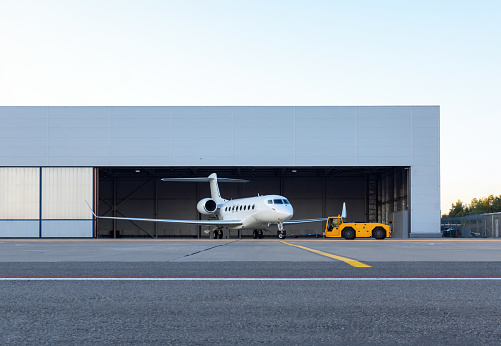 Jet de negocios de lujo está siendo remolcado fuera del hangar photo