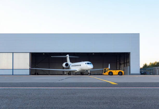 Luxury business jet is being towed out of the hangar One of the most expensive and prestigious private jets in the world. Ground handling preparations for the flight. American made model airplane hangar stock pictures, royalty-free photos & images