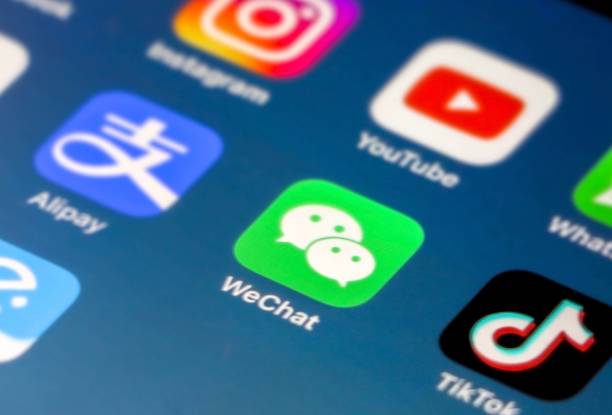 iphoneのスマートフォン画面に焦点を当てたwechatアプリケーションアイコン、青いグラデーションの背景の壁紙に焦点が当てられていない他のアプリ(tik tok、alipay、instagramなど) - twitter iphone apple computers application software ストックフォトと画像