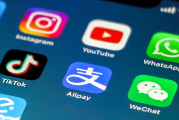 aplicativos chineses de mídia social, wechat, alipay e tik tok em foco, como 3 aplicativos de mídia social ocidental, instagram, youtube e whatsapp estão fora de foco - ipad apple computers digital tablet editorial - fotografias e filmes do acervo