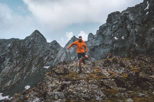 Man trail running alone hiking in mountains travel climbing adventure active extreme vacations outdoor healthy lifestyle freedom concept stock photo