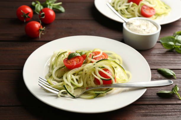 istock Tasty zucchini pasta with tomatoes and basil served on wooden table 1387858607