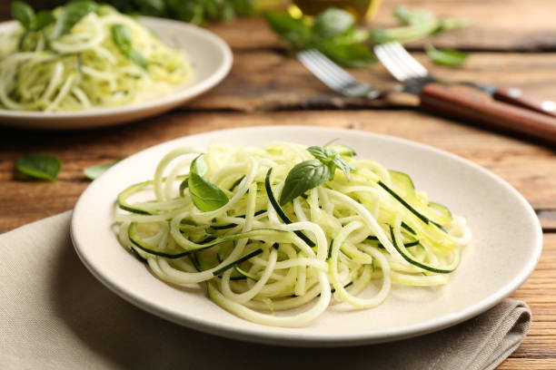 istock Tasty zucchini pasta with basil served on wooden table 1387858697
