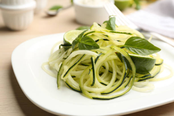 istock Tasty zucchini pasta with basil and lime on table, closeup 1387858845